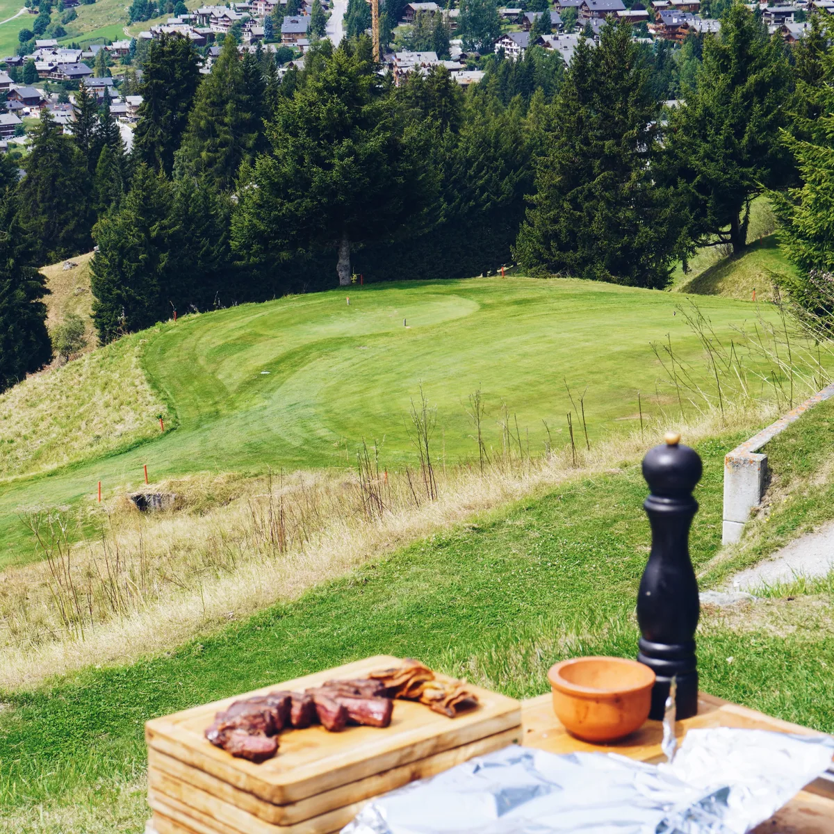 Entraña sliced on a board, the tenth green and Verbier behind it