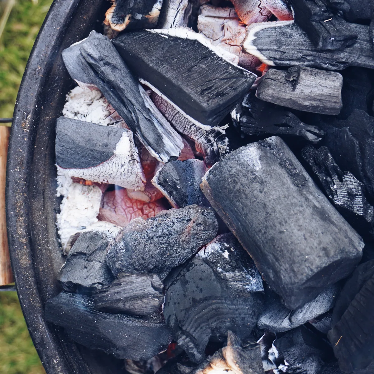 Charcoal just lit in the fire pit, the first embers showing