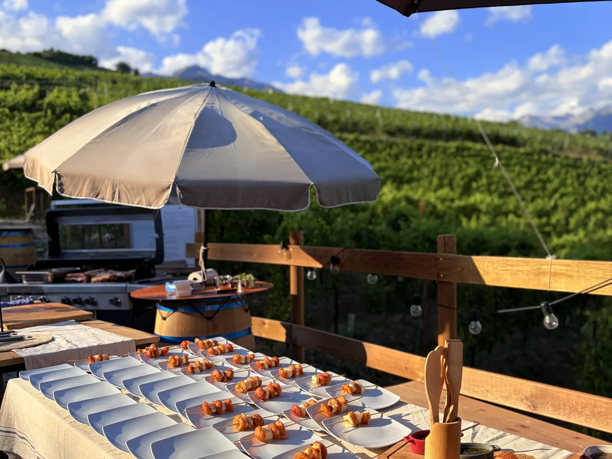 Plated bites lined up along a table above the vineyard at Les Celliers de Sion
