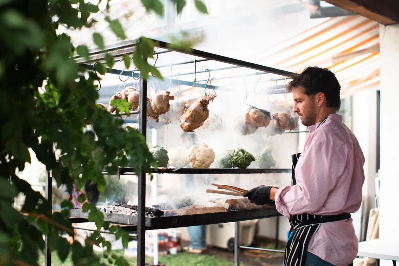 Pancho at the grill tower, chickens and broccoli on the racks