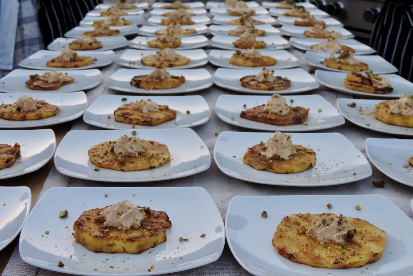 Dozens of plates lined up along the table, all the same dish