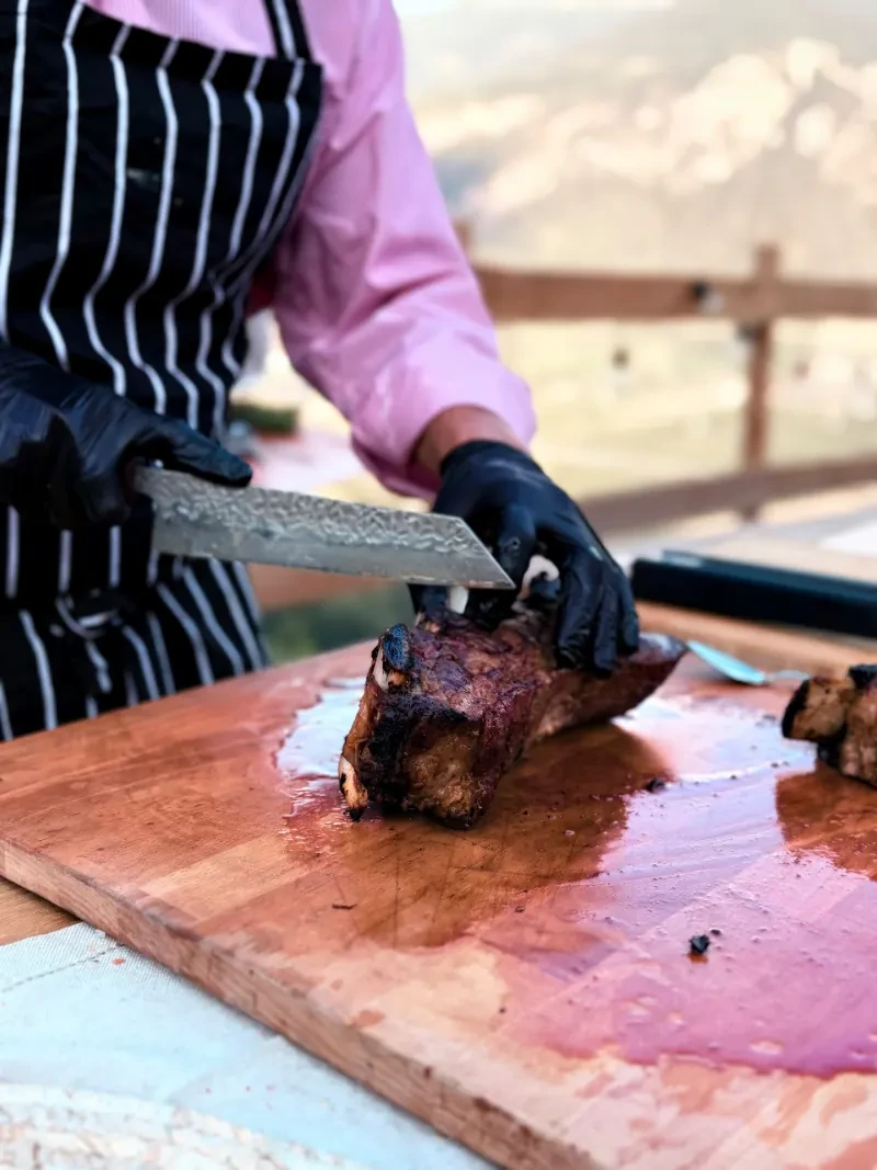 Hands slicing a rib cut on the board