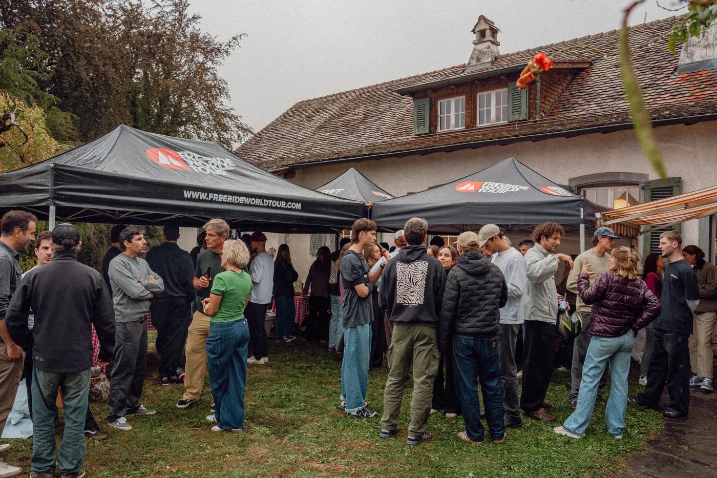 Guests standing under the Freeride World Tour tents on the grass