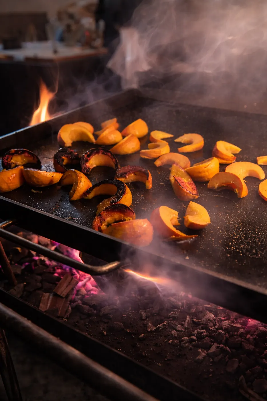Pumpkin wedges caramelising on the grill over the flame