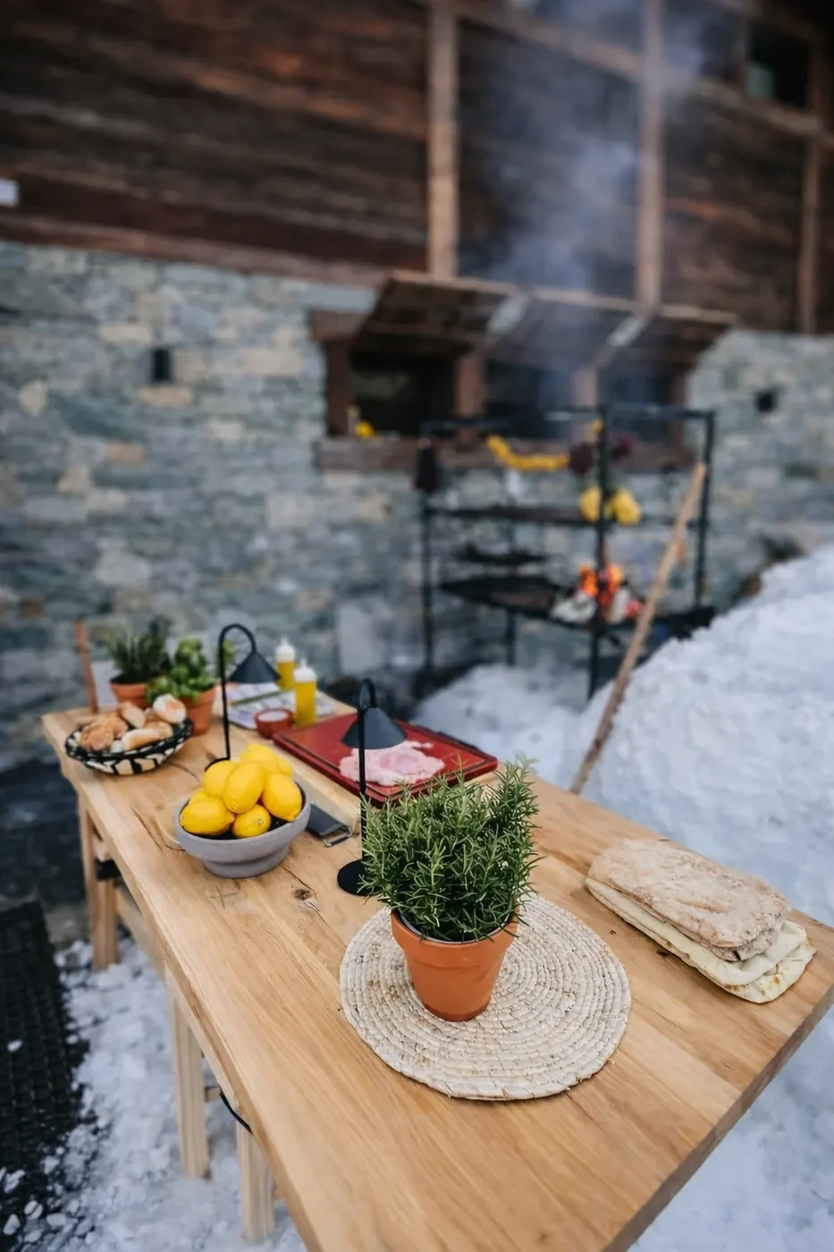 A table set outside in the snow, next to the chalet